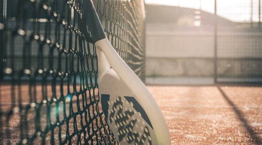 Padel blade racket resting on the net